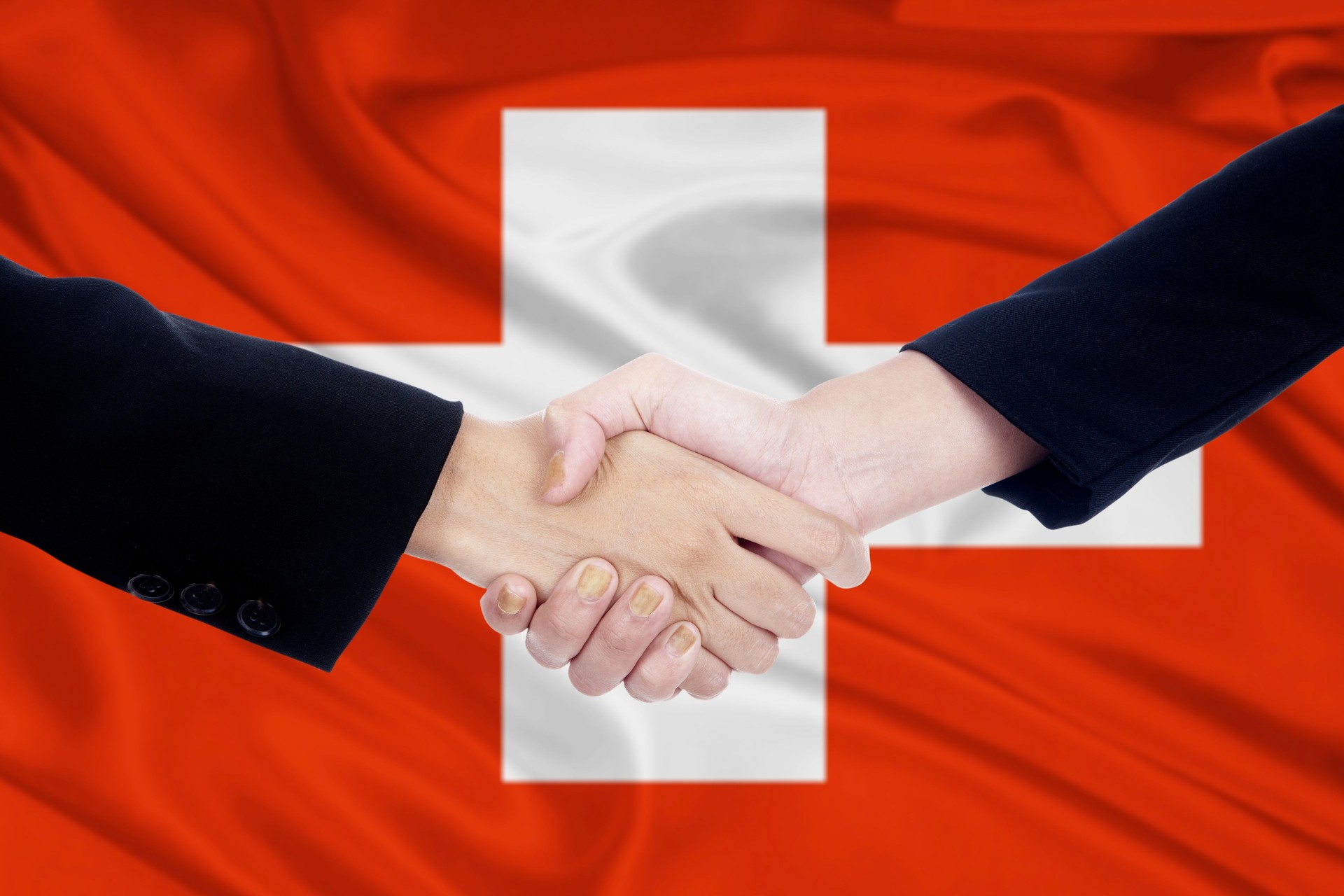 Hände schütteln mit Flagge der Schweiz